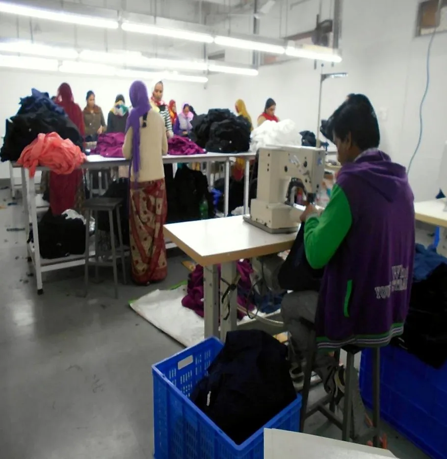 Garment finishing with a buttonhole machine and inspection tables