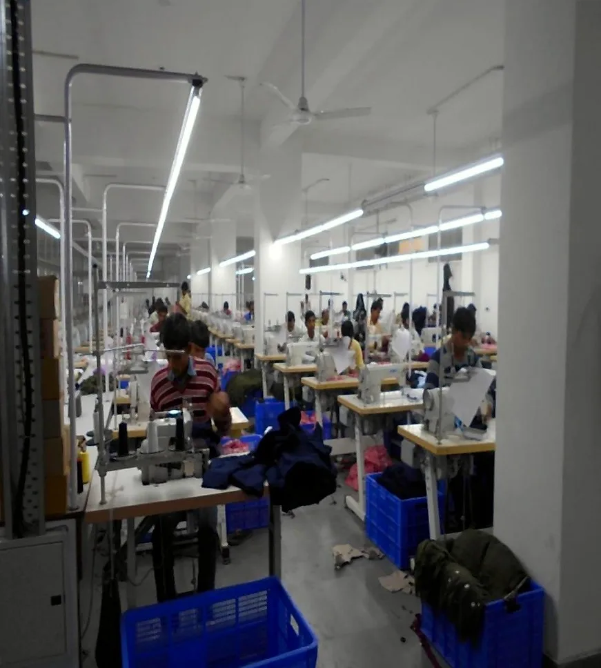 Long stitching line with overhead lighting and bins of cut work