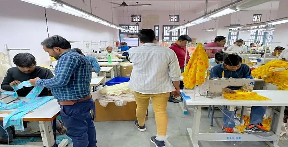 Supervisor reviewing printed garments with tailors on the production line